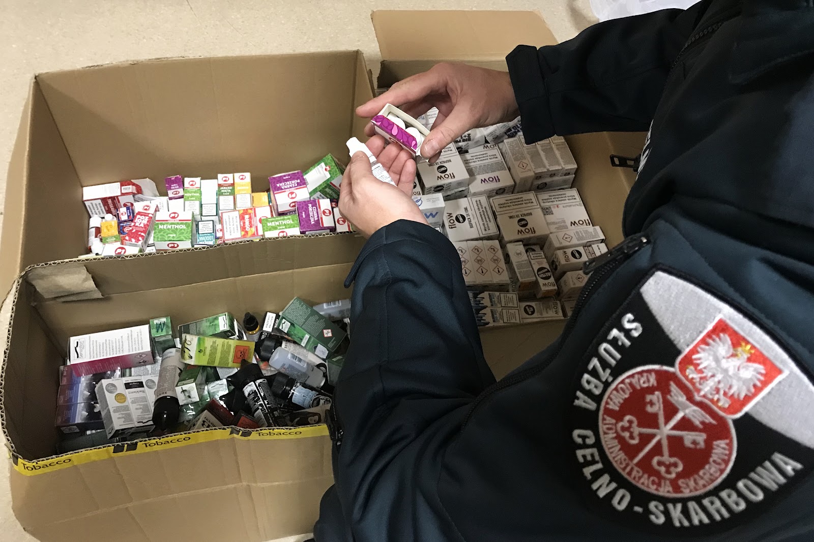 Zbliżenie na butelkę z płynem do waporyzacji z wyraźnie widoczną banderolą akcyzową z datą 2026, świadczącą o legalności produktu.